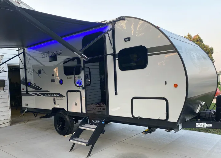 New Wolf Pup travel trailer, a great option for an rv rental adventure, featuring a lit awning and easy access steps.. Forest River Other 2021