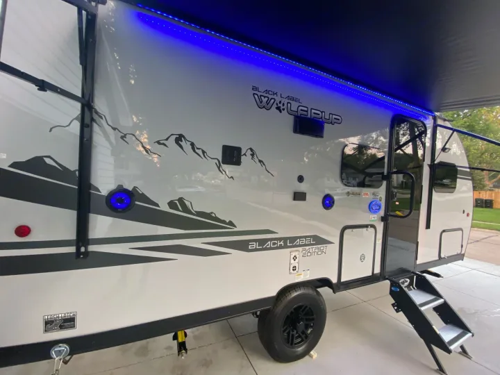 Modern light grey travel trailer for rv rental, featuring cool blue awning lights & mountain decals. Ready for your outdoor adventure.. Forest River Other 2021