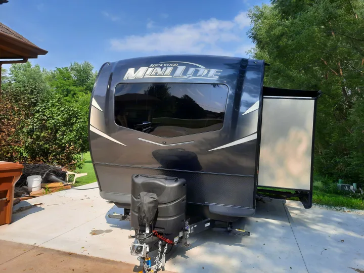 Front view of a dark grey Rockwood Mini Lite RV, parked on concrete with its slide-out extended. Ideal for an rv rental.. Forest River Rockwood Mini Lite 2021