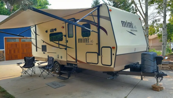 This RV rental: a beige Rockwood Mini Lite travel trailer parked on a driveway with its awning extended & chairs out.. Other Other 2016