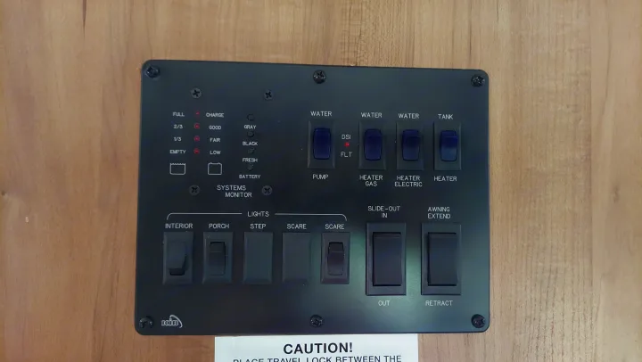 RV rental control panel. Black panel with switches for lights, water pump, heaters, slide-out, and awning. Shows tank/battery levels.. Other Other 2016