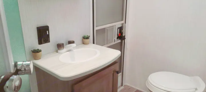 Inside an RV rental, a compact and clean bathroom featuring a sink, vanity, and toilet for your comfort.. Heartland Pioneer 2021
