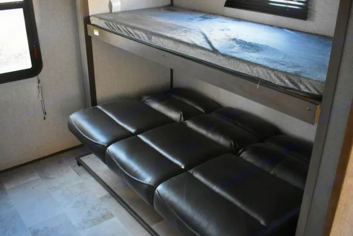 RV rental: Bunk beds above a black leather convertible sofa, maximizing sleeping space in this RV interior.. Dutchmen Coleman 2021