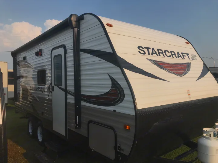 White and gray Starcraft Autumn Ridge travel trailer, equipped with propane tanks, ready for RV rental adventures.. Starcraft Autumn Ridge 2018