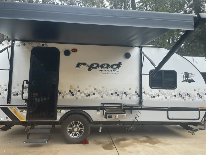 Exterior with optional grill and side table. Forest River R-Pod 2021