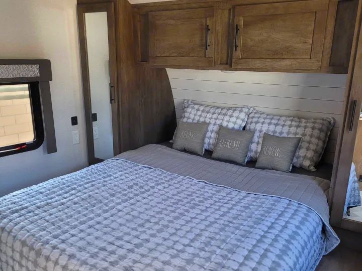 Cozy RV rental bedroom featuring a comfortable bed, modern gray decor, ample storage, and serene accents.. Forest River Salem 2021