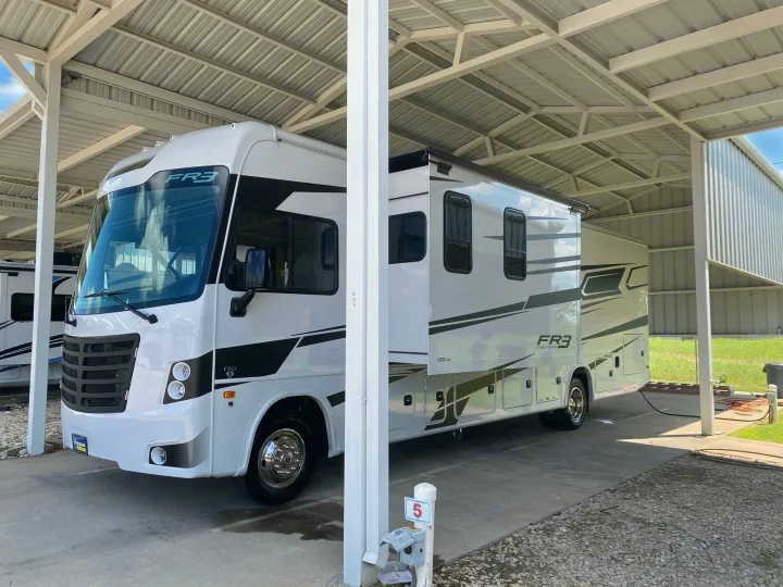 This white FR3 Forest River RV rental is neatly parked under a covered carport, ready for its next adventure.. Forest River FR3 2021