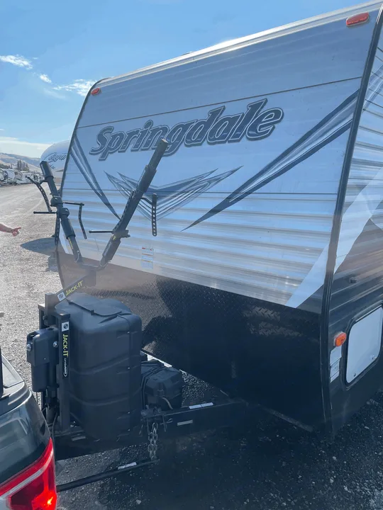 A Springdale travel trailer, featuring a JACK-IT bike rack, hooked up for an RV rental adventure. Ideal for biking trips!. Keystone Springdale 2017