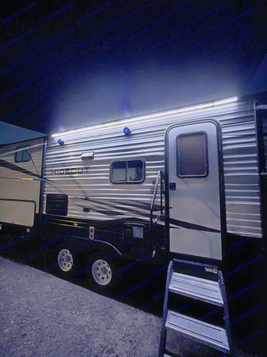 An rv rental illuminates the night with bright strip lights and blue accents, showcasing its steps.. Keystone Hideout 2021