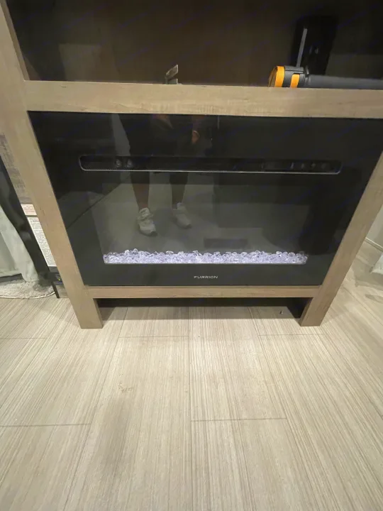 RV rental features: A sleek electric fireplace with crystal "embers" on wood flooring.. Keystone Hideout 2021