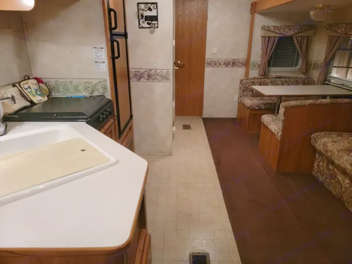 Cozy RV rental interior: kitchen with sink & stove, dining booth, and comfortable living area.. Palomino Puma 2005