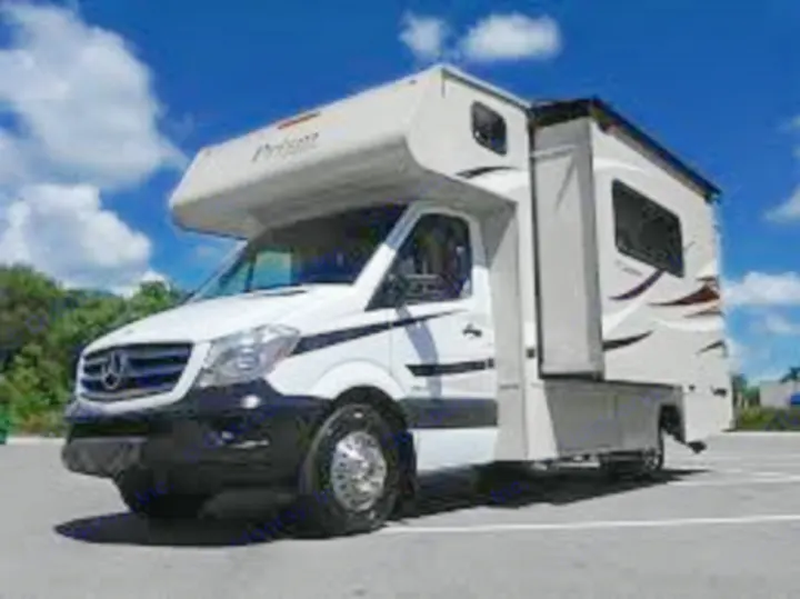 White Mercedes Sprinter Class C RV rental, a motorhome with slide-out, parked outdoors on asphalt.. Coachmen Prism 2016