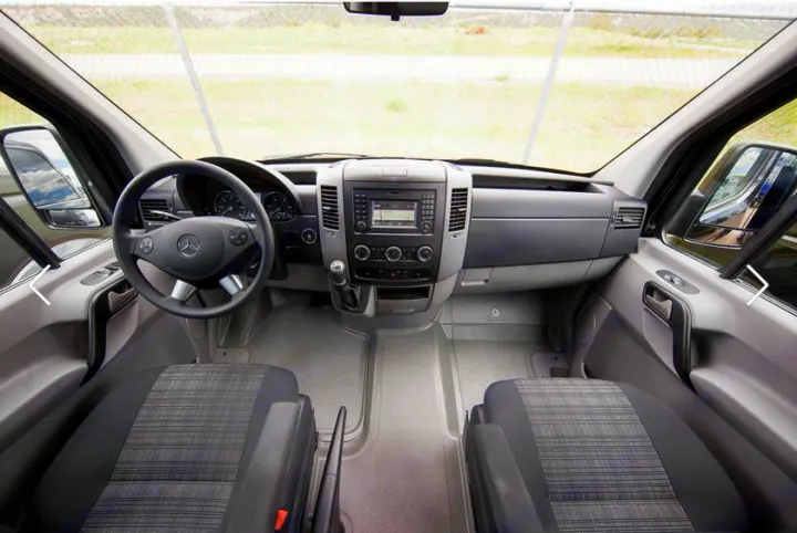 Spacious Mercedes-Benz van cockpit, perfect for an RV rental. Features a detailed view of the dashboard, steering wheel, and front seats.. Coachmen Prism 2016