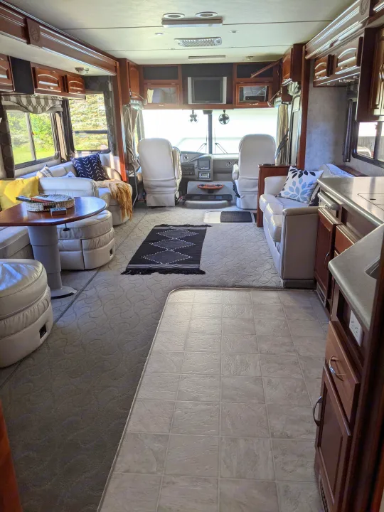 Spacious RV rental interior featuring a comfortable living space with dinette and kitchen, leading to the driver's area.. Fleetwood Pace Arrow 2007