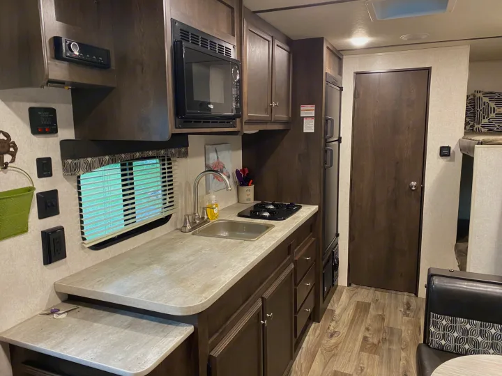Experience comfort in this rv rental. Features a kitchenette with microwave, sink, stove, fridge, and bunk bed area.. Starcraft Autumn Ridge 2018