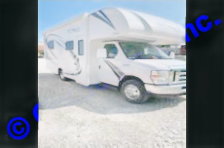 A white, modern RV rental motorhome, perfect for your next road trip adventure, seen parked on a gravel lot.. Thor Motor Coach Freedom Elite 2019