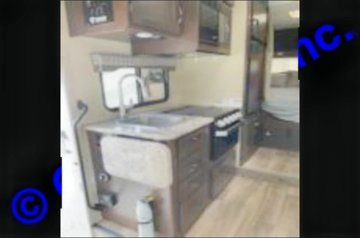 RV rental interior: well-equipped kitchen featuring a sink, stove, microwave, and view into the bedroom area.. Thor Motor Coach Freedom Elite 2019