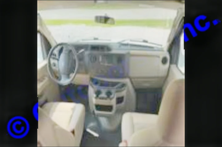 Inside an RV rental: the clean, spacious front cabin, featuring a steering wheel, dashboard, and front seats.. Thor Motor Coach Freedom Elite 2019