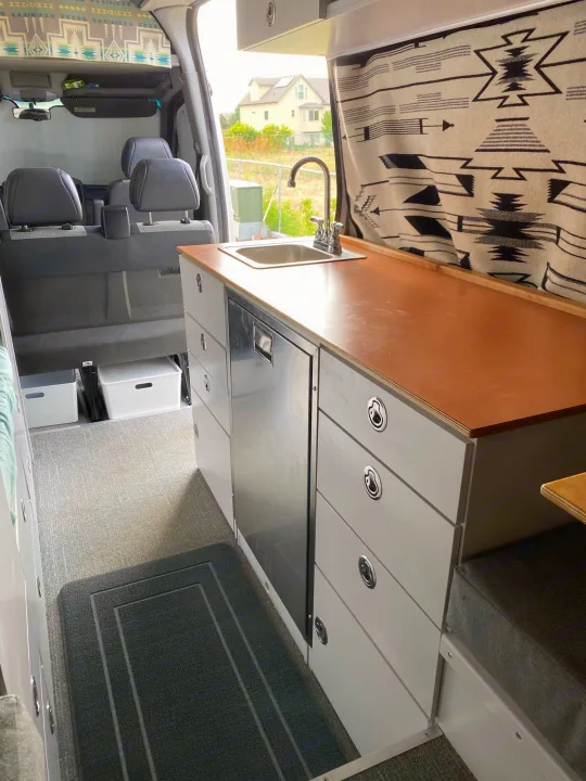 Inside this spacious rv rental, a compact kitchen with sink, fridge, storage drawers, and seating area awaits your journey.. Dodge Sprinter 2500 170ext 2008
