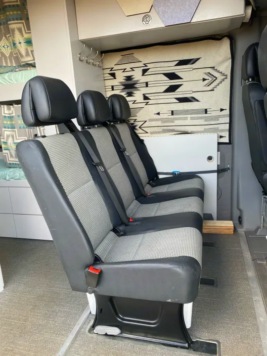 Spacious RV rental interior: three passenger seats, bunk bed, and storage. Perfect for road trips.. Dodge Sprinter 2500 170ext 2008