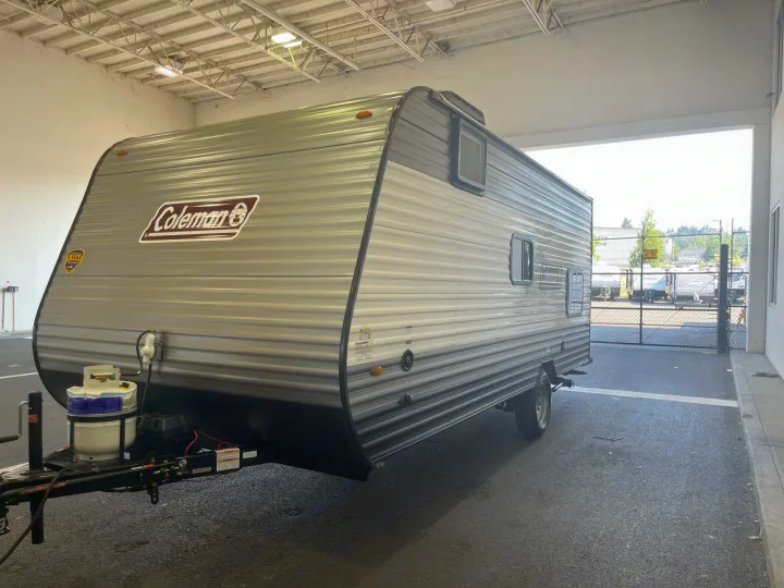 Gray Coleman travel trailer parked indoors, ready for RV rental. Ideal for your next camping trip.. Other Other 2021