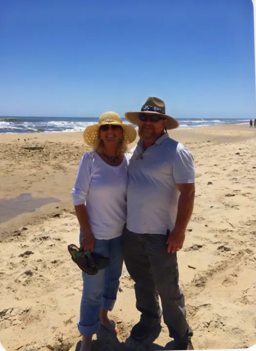 Couple enjoying a sunny beach, standing barefoot on sand near the ocean. An ideal RV rental adventure.. Coleman COLEMAN LANTERN 2021