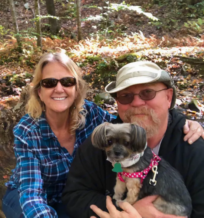 Smiling couple, dog in arms, enjoying a forest outing. Plan your next nature adventure with an RV rental.. Coleman COLEMAN LANTERN 2021