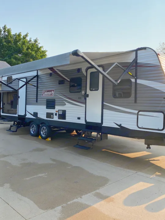 Ready for adventure: a modern Coleman travel trailer RV rental parked outdoors with awning extended, perfect for your next getaway.. Dutchmen Coleman 2019