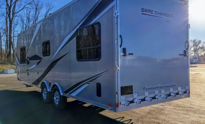 Explore with this gray Game Changer toy hauler for rv rental. A spacious recreational trailer with windows & rear ramp.. Aluminum Trailer Company 2816 2021