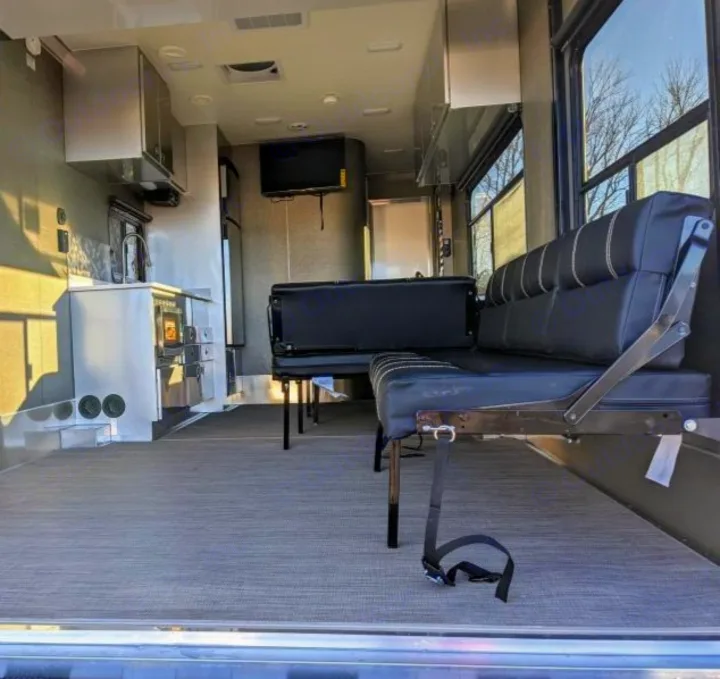 Spacious RV rental interior: a toy hauler's versatile living space with kitchen, convertible seating, and modern amenities.. Aluminum Trailer Company 2816 2021