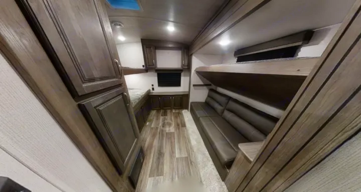 This RV rental interior features a bunkhouse with a comfy sofa, lower bed, and abundant storage. Perfect for family adventures.. Keystone Cougar Half-Ton 2021