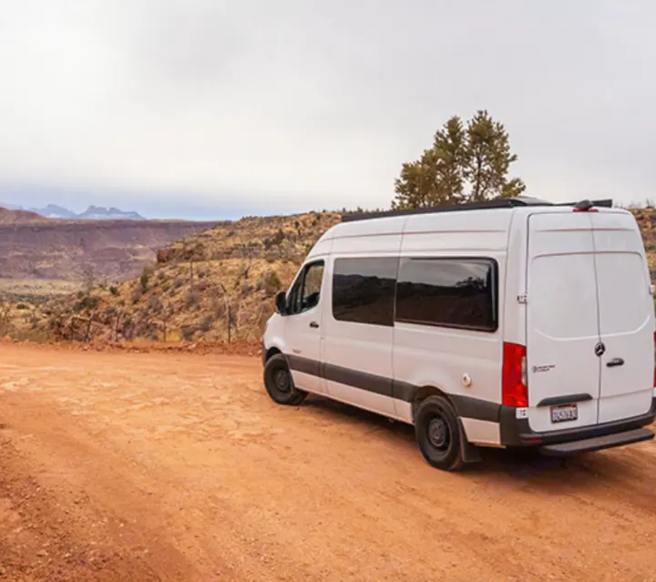 White Sprinter rv rental parked on a red dirt road overlooking a vast desert canyon.. Mercedes-Benz Sprinter 2020
