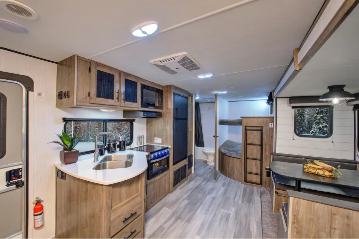 Spacious RV rental interior with modern kitchen, dinette, bunk beds, and bathroom, perfect for travel adventures.. Heartland Pioneer 2021