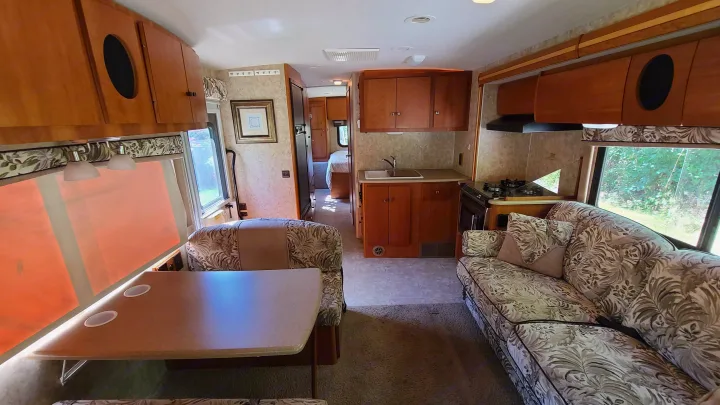 Spacious RV rental interior with living area, kitchen, and a hallway leading to the bedroom, ideal for travel.. Itasca Spirit 2007