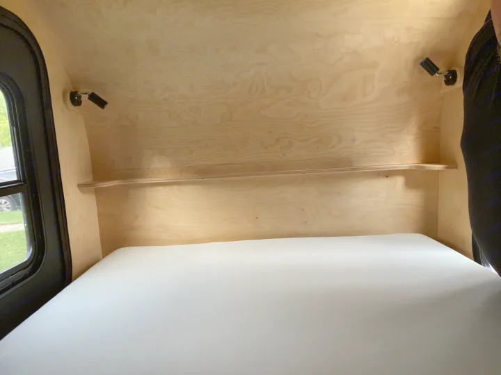 Experience comfort in this RV rental! The cozy interior features light wood paneling, a soft white mattress, and practical reading lights.. Other Other 2021