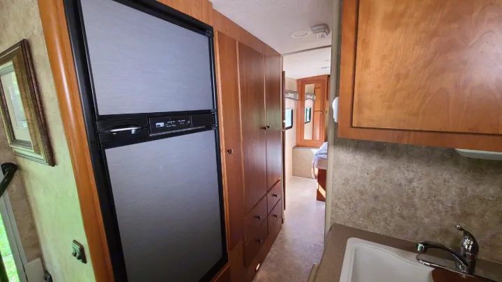 RV rental: Compact interior features kitchen with fridge & sink, plus wood cabinets and hallway leading to bedroom.. Itasca Spirit 2007