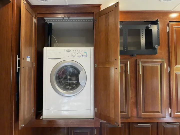 Built-in Splendide washer in RV rental: ideal for on-the-go laundry within wood cabinetry.. Forest River Forester 2018