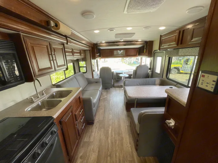 Explore this inviting RV rental interior, showcasing a well-equipped kitchen, comfortable sofa, and dinette.. Forest River Forester 2018