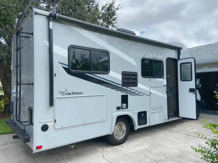 This gray Coachmen Prism Class C RV rental, parked on a driveway, awaits its next road trip.. Mercedes-Benz Sprinter Coachmen Prism 2021