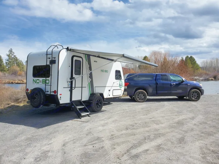 This RV rental, a NO BO camper & Toyota Tundra truck, is parked by the water for outdoor adventure.. Forest River Other 2019