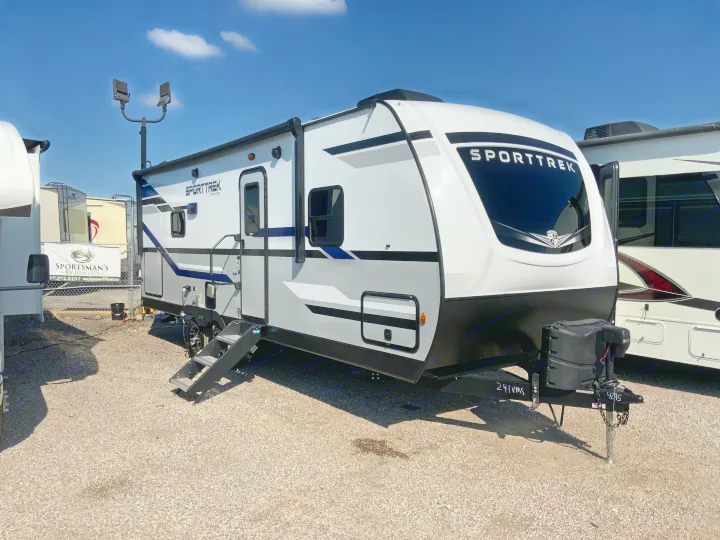 A new Sporttrek travel trailer, white and gray, parked on a gravel lot, ready for rv rental.. Venture Rv Sporttrek 2022