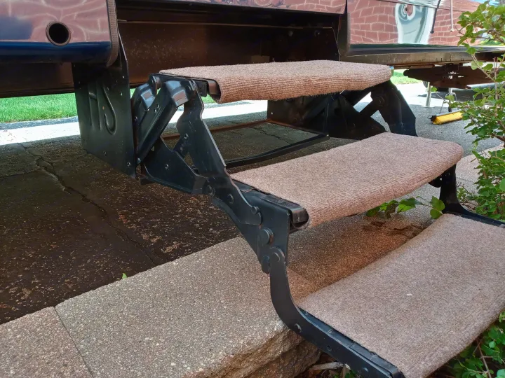 Carpeted folding steps of an RV rental, offering stable and comfortable access to the vehicle's interior.. Holiday rambler Traveler 2013