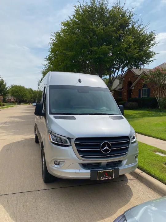 Silver Mercedes Sprinter van parked on street, ready for your RV rental adventure.. Mercedes-Benz Sprinter 2021