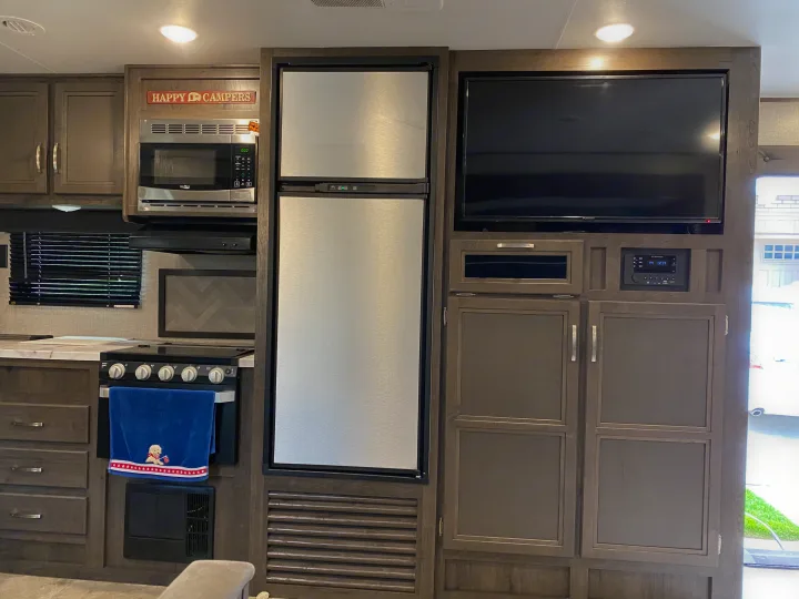 RV rental interior: modern kitchen with microwave, stove, fridge; entertainment center with TV/stereo. Comfortable living.. Jayco Jay Flight 2020