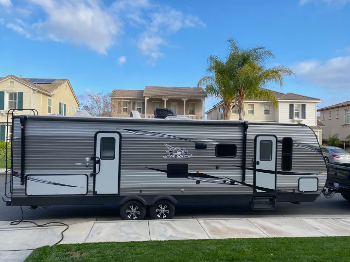 This Jay Flight travel trailer, ideal for an RV rental, is parked in a residential area, ready for adventure.. Jayco Jay Flight 2020
