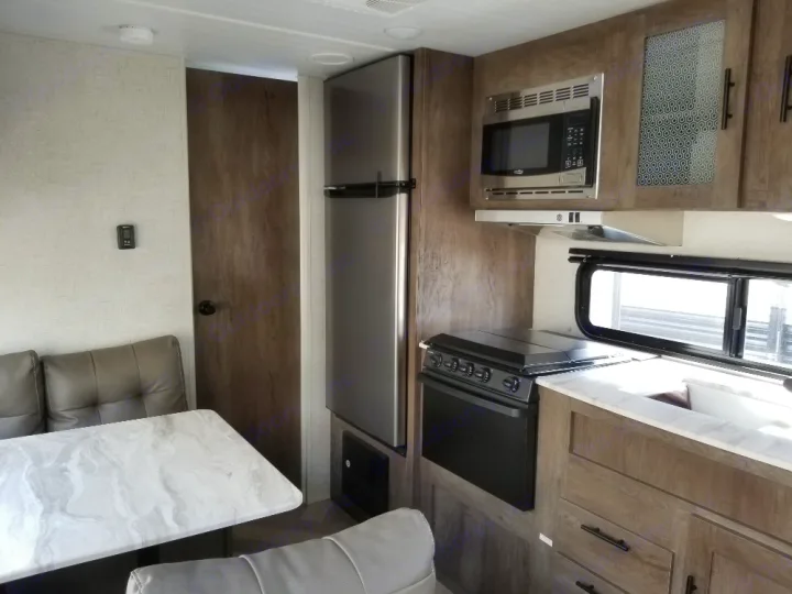 Modern RV rental interior featuring a full kitchen with appliances, dining area, and comfortable seating.. Forest River Salem Cruise Lite 2021