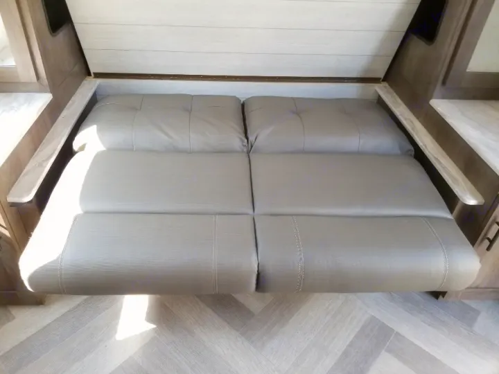 Modern gray modular seating in an RV rental, likely converting to a bed. Ideal for compact camper interiors.. Forest River Salem Cruise Lite 2021