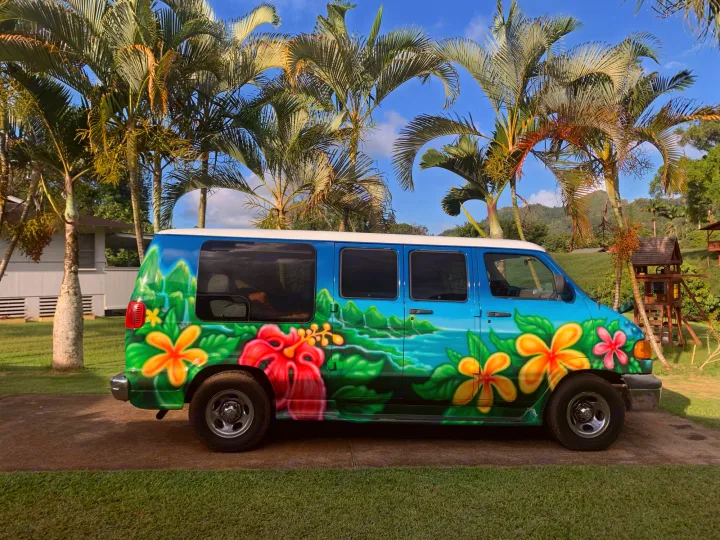 Colorful rv rental van, painted with vibrant tropical flowers and island scenes, parked under palm trees.. Dodge Ram 1500 1999