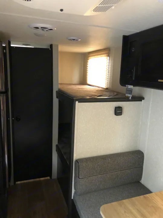 Tour this RV rental's cozy interior, showcasing comfy bunk beds, a practical dinette, and compact amenities.. Forest River Wolf Pup 2021