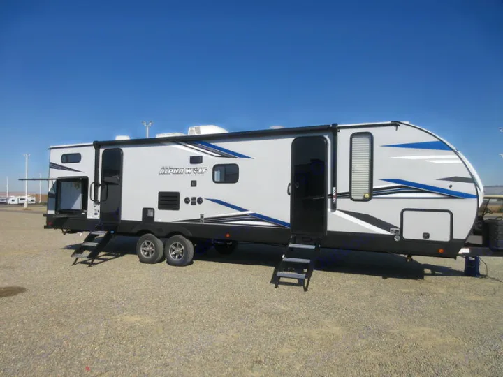 Explore the outdoors! This grey Alpha Wolf travel trailer, an ideal rv rental, features blue graphics and extended steps.. Forest River 30DBH-L 2021